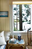 Bright, wood-clad room with tranquil view of lake through tall pines