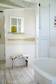 weiße Lamellentüren, Fensterspiegel mit maritimer Deko und Vintage-Bank in Landhaus-Badezimmer