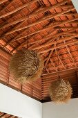 Textured pendant shades hang from beamed ceiling of beach house retreat in the Indian state of Goa