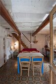 Wohraum mit rustikaler, weiss getünchter Zimmerdecke und renovierten Vintagemöbeln