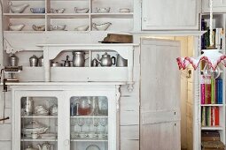 weiße Küchenwand im Shabby Stil mit Vitrine und umfangreicher Geschirrsammlung