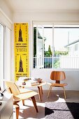 Klassikerstühle und Beistelltisch (Charles Eames)in heller Zimmerecke vor offenem Fenster