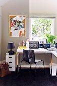 Quiet, bright work space in a garden shed with a corner desk under the window and black carpeting