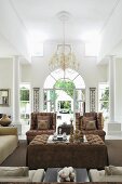 Exclusive living area with white columns, chandelier and elegant upholstered furnishings