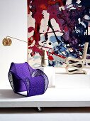 Designer-Stühle und Lampe vor Wandteppich