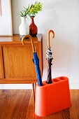 Orange, original umbrella stand with umbrellas inside