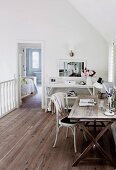 Home office on gallery with white shelves and wooden floor