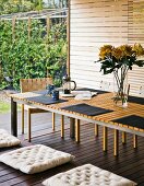 Modern table and bench on veranda of wooden house