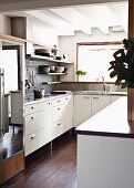 White fitted kitchen with dark wooden floor