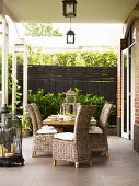 Wooden table and wicker chairs on terrace with antiquated decorative elements