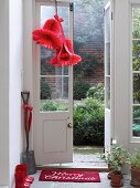 Rote Deko-Glocken zum aus Wabenpapier hängen an der Tür