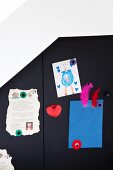 Children's work attached to black cupboard door with magnets