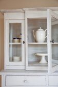 White china crockery and large, white coffee pot in white, shabby chic dresser