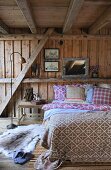 Schlafzimmer mit Doppelbett in einer Holzhütte