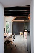 Study under dark, wood-beamed ceiling with green vintage ladder and grey fitted cupboards