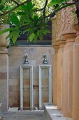 Twin outdoor showers on sandstone wall and impressive stone columns decorated with traditional patterns