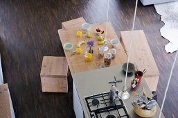 Blick von oben auf freistehenden Küchenblock und Esstisch mit Frühstücksgedecken