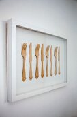 Framed artwork made from row of wooden knives and forks