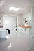 Purist ensuite bathroom with polished white floor and wooden washstand counter