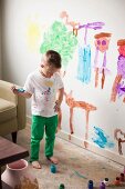Toddler boy (2-3) painting on wall