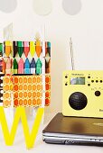 Notebook, Radio und bunte Dekoration auf weißem Schreibtisch