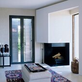 Open fireplace next to French windows in elegant living room