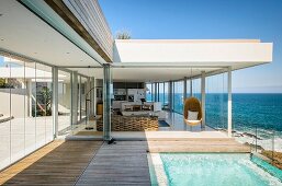 Living room with sea view and long glass wall; infinity pool with glass balustrade in foreground