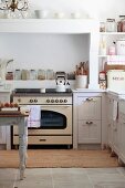 Vintage cooker below masonry extractor hood in white, country-house kitchen