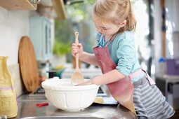 A girl stirring dough in a bowl