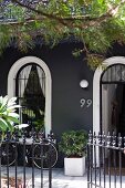 Elegantes Wohnhaus mit dunkelgrauer Fassade und offene schmiedeeiserne Gartentür