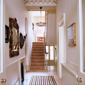 Victorian entry hall - view of a narrow hallway with decorative objects on the wall and antique hanging light on the plaster ceiling above the stairway