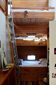 Ladder next to wooden bunk beds in small children's bedroom