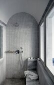 Shower area with mosaic tiles on walls and floor and barrel-vaulted ceiling