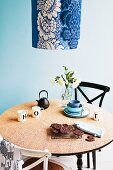 Revamped breakfast table with cork top, vintage chairs and pendant lamp with blue and white floral lampshade