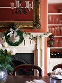 Gilt-framed mirror and Christmas decorations above ornate open fireplace