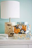 Gifts packaged in floral gift wrap in front of table lamp