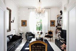 Modern, black leather sofa set and Renaissance chairs decorated with writing in gold in elegant living room