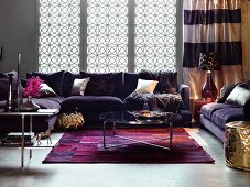 Glamouröses Wohnzimmer mit violetter Polstergarnitur, Teppich und goldfarbenem Sitzpouf