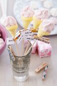 Marshmallows shaped like ice cream cones on skewers with mottoes on clothes pegs