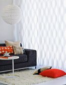 Weisser wellenförmiger Vorhang im Wohnzimmer mit Kugelleuchte und grauem Sofa