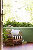 Inviting bamboo armchair on veranda with green parapet wall and exotic wood parquet floor
