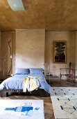 Einfaches Doppelbett und originelle Sammlerstücke zu marmorierter Wand- und Deckengestaltung