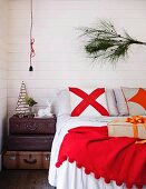 Pine branch as Christmas decoration in bedroom above double bed
