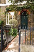 Georgian-style, English house with wrought iron fence around front garden