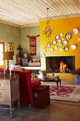 Sofa and coffee table on rug in front of collection of plates on yellow-painted wall above open fireplace in rustic setting