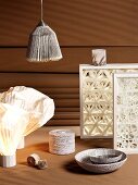 Wooden frames containing artistic 3D patterns, lampshades and vessels made from artistically processed paper