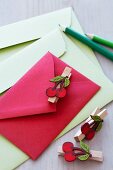 Colourful envelopes decorated with clothes pegs with cherry motifs