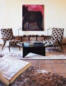 Two retro armchairs with geometric upholstery in front of modern painting of horse; hand-crafted patchwork leather easy chair and rugs in foreground
