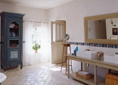 Badezimmer im Landhausstil mit Doppelwaschbecken, Holzspiegel & antikem blauen Holzschrank