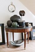 Round, antique side table with marble top decorated with various ceramic vases and objets d'art